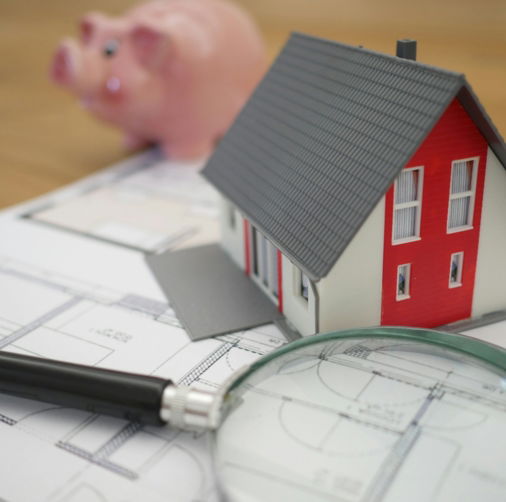 white and red wooden house beside grey framed magnifying glass
